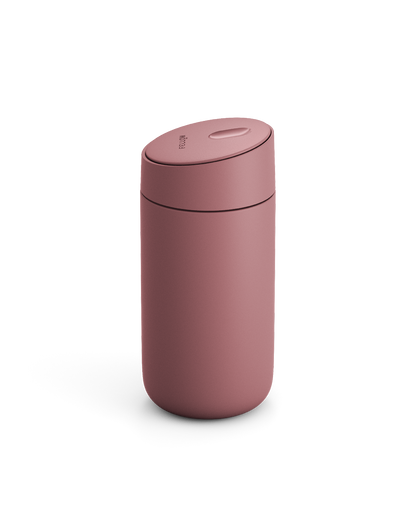 The Fellow Carter Slide Mug, a pink reusable travel cup with a rounded lid, on white background.