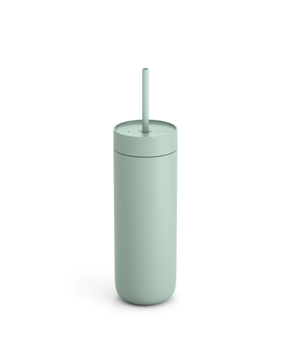 The Fellow Carter Cold Tumbler in matte light green with a straw on a white background.