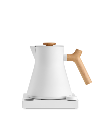 Fellow Corvo EKG Electric Kettle with wooden handle on a sleek white base.
