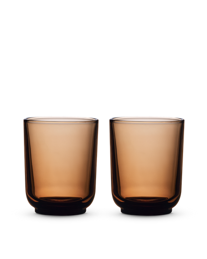 Two Fellow Pirch Espresso Glasses in amber sit on a white background.