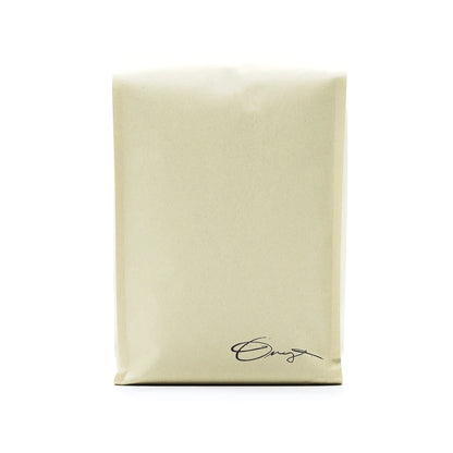 A beige Monarch bag by Onyx Coffee Lab with a small cursive logo and dark chocolate coffee notes.